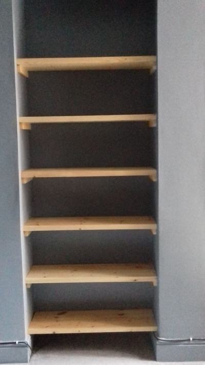 Pine shelves in dark-walled alcove