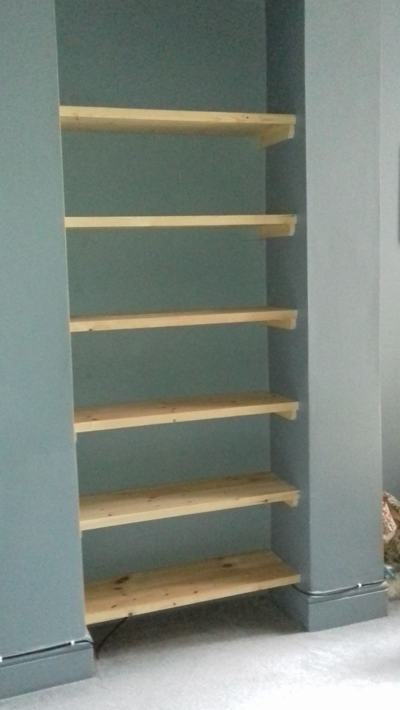 Alcove shelves in teal painted recess