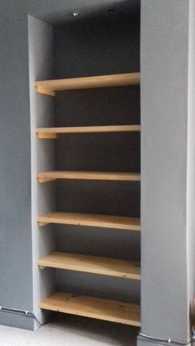 Alcove shelves in grey painted recess with downlight