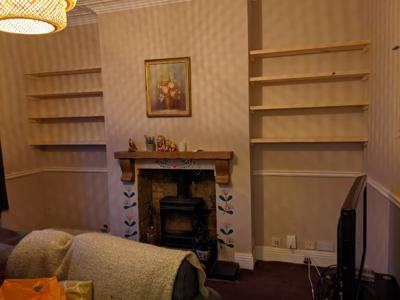 Alcove shelves both sides of fireplace with wood burner