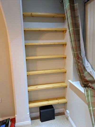 Pine alcove shelves beside window with curtain