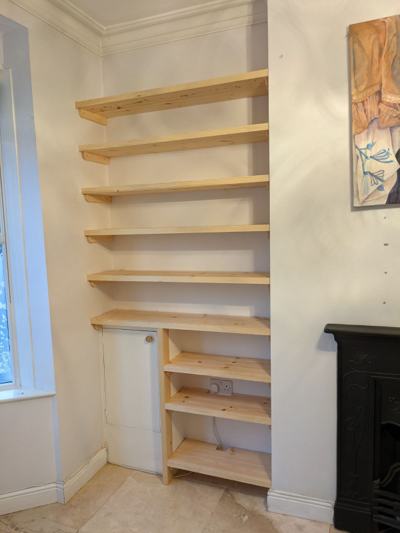 Alcove shelves with cupboard beside fireplace