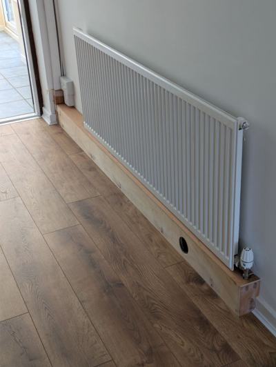 Boxing in pipework beneath radiator