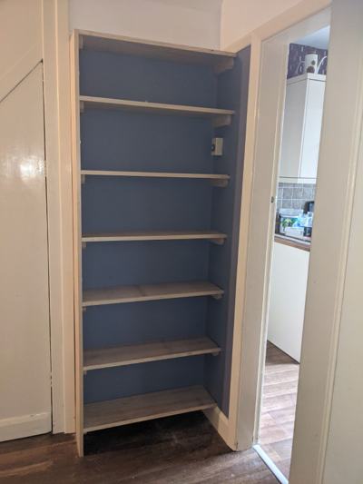 Shelving in cupboard with blue walls
