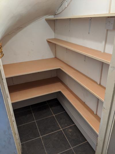 L-shaped shelving in under-stairs cupboard