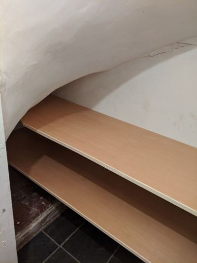 Curved shelving fitted under stairs