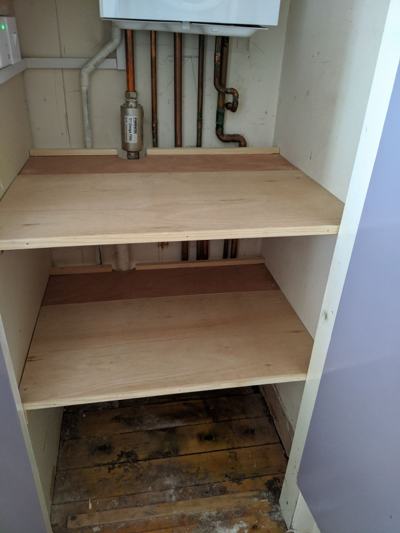 Shelves fitted around boiler in cupboard